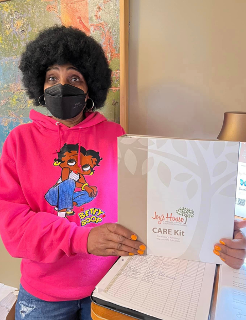 Woman with covid mask holding Joys House Care Kit